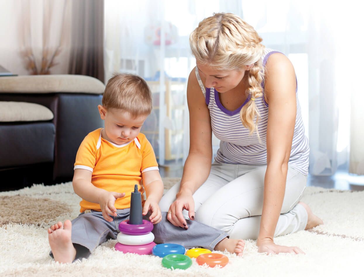 A woman playing with a child on the floor A woman playing with a child on the floor A woman playing with a child on the floor