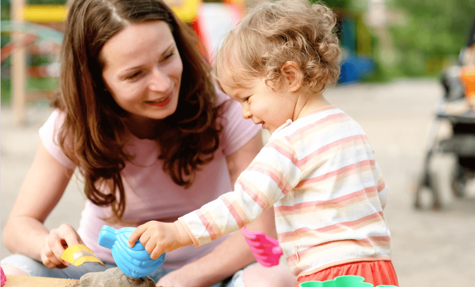 A woman and a child playing with sand